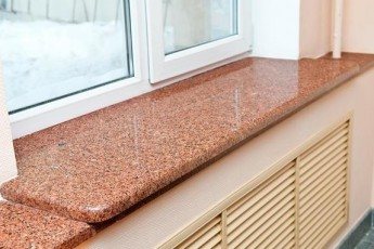 Alféizar de granito rosa con toques oscuros de rojo arce